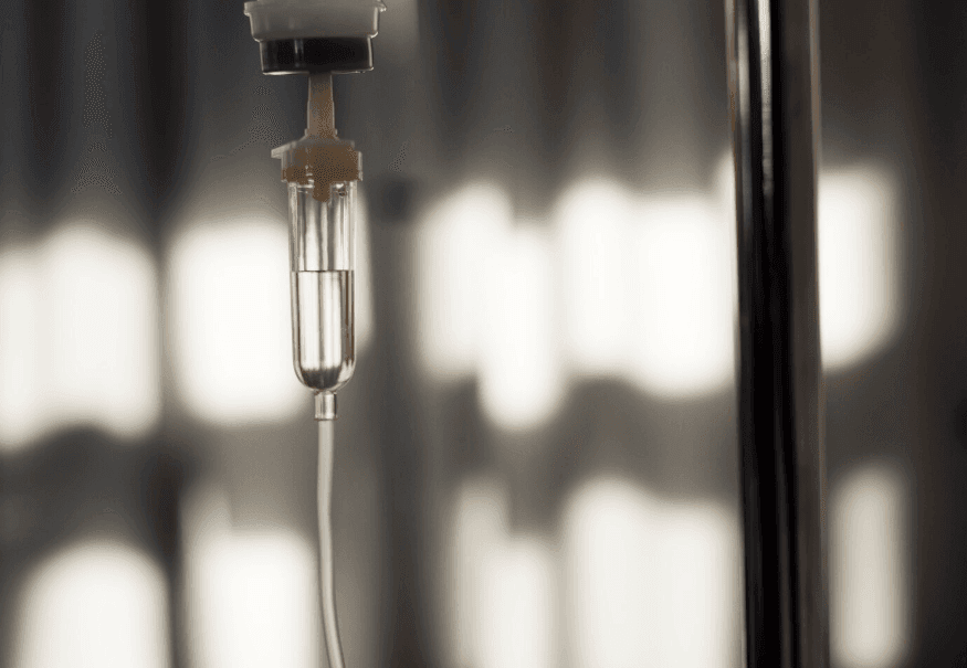 Close-up of a clear IV drip chamber and tubing.