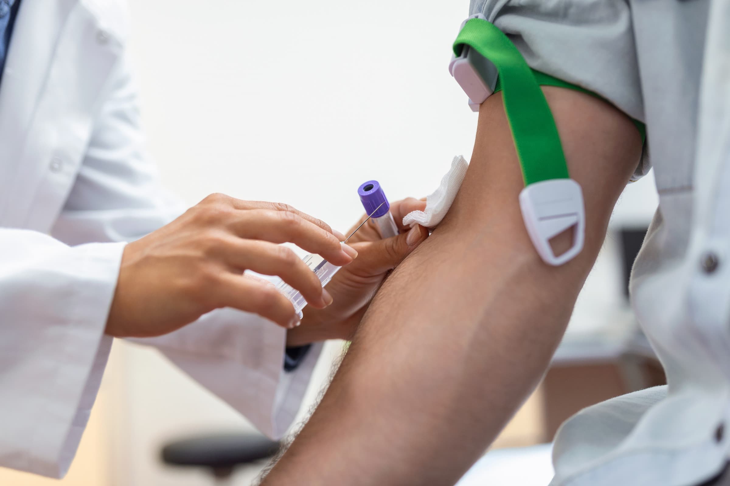Clinician drawing a blood sample into a collection tube for an iron blood work test