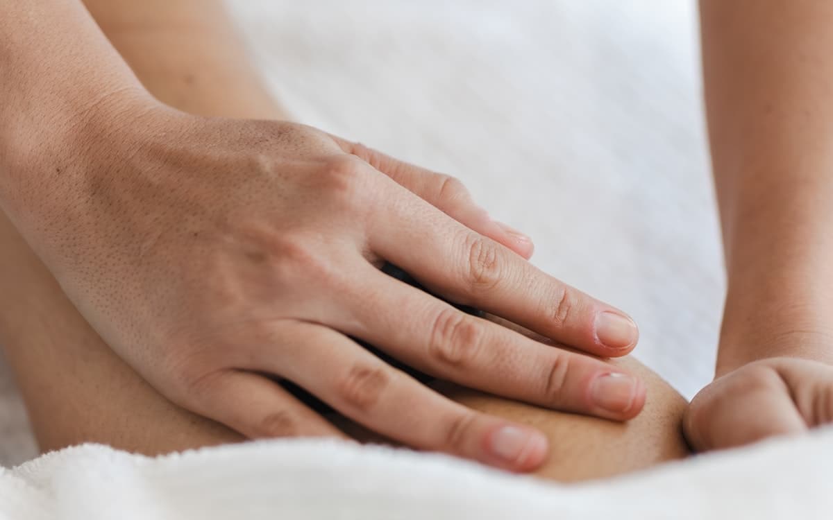 A therapist applying firm pressure along a person's back