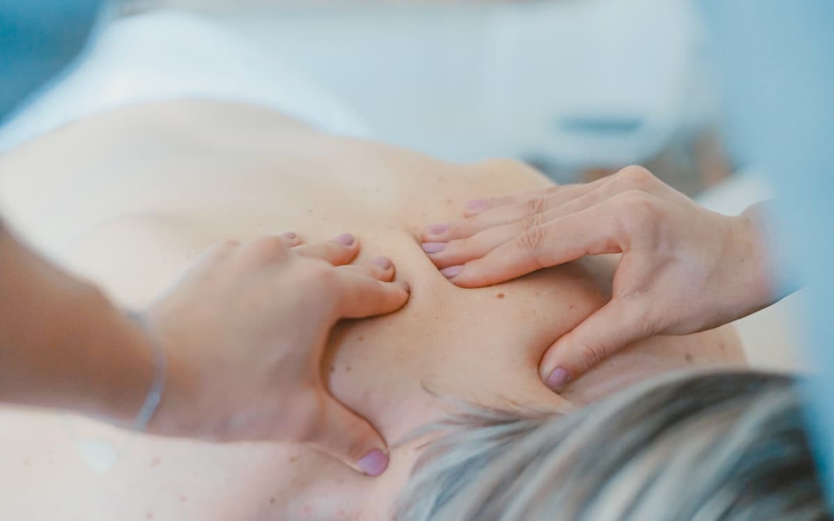 Hands resting gently on a person's shoulders during a relaxation massage
