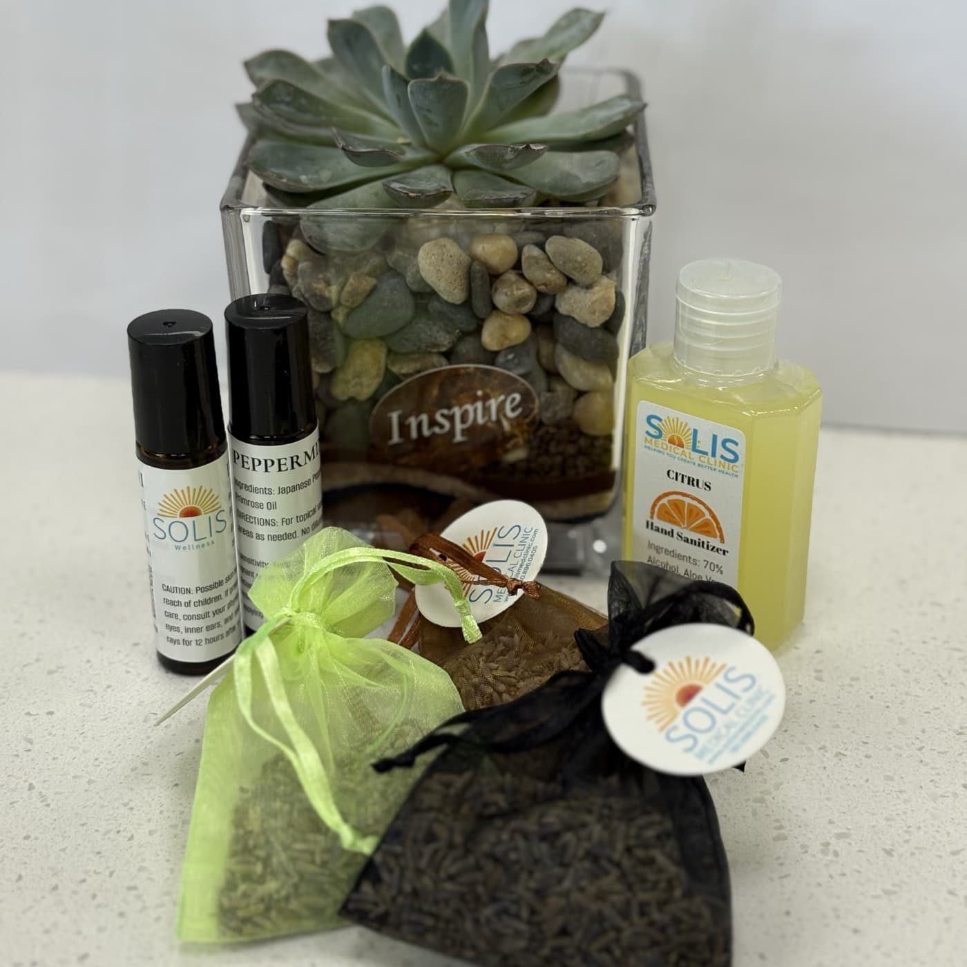 Solis Wellness peppermint roller oils, a Solis citrus hand sanitizer and lavender sachets on the counter at Solis Medical Clinic.
