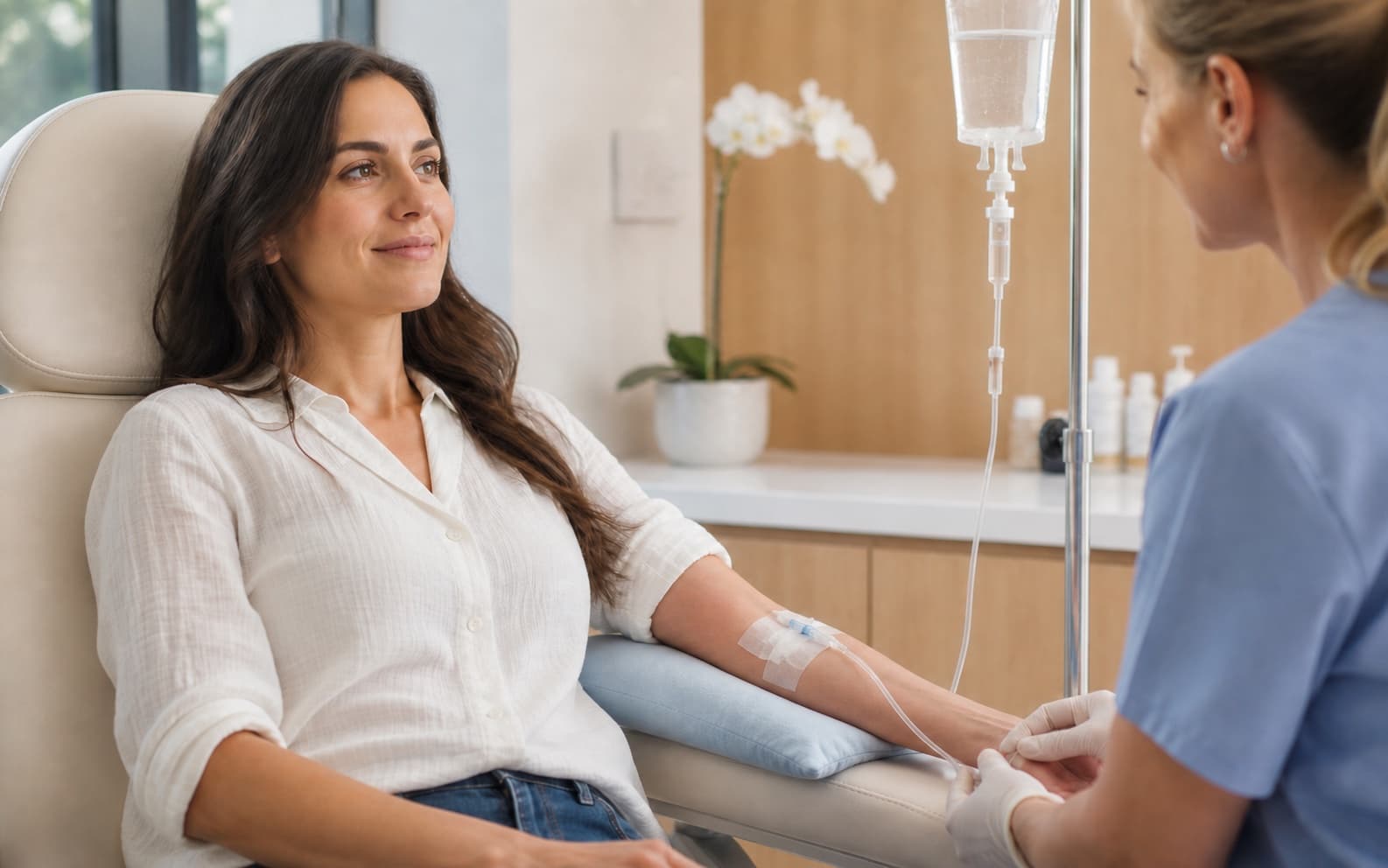 Adult patient receiving Vitamin C IV treatment while a nurse checks the infusion line